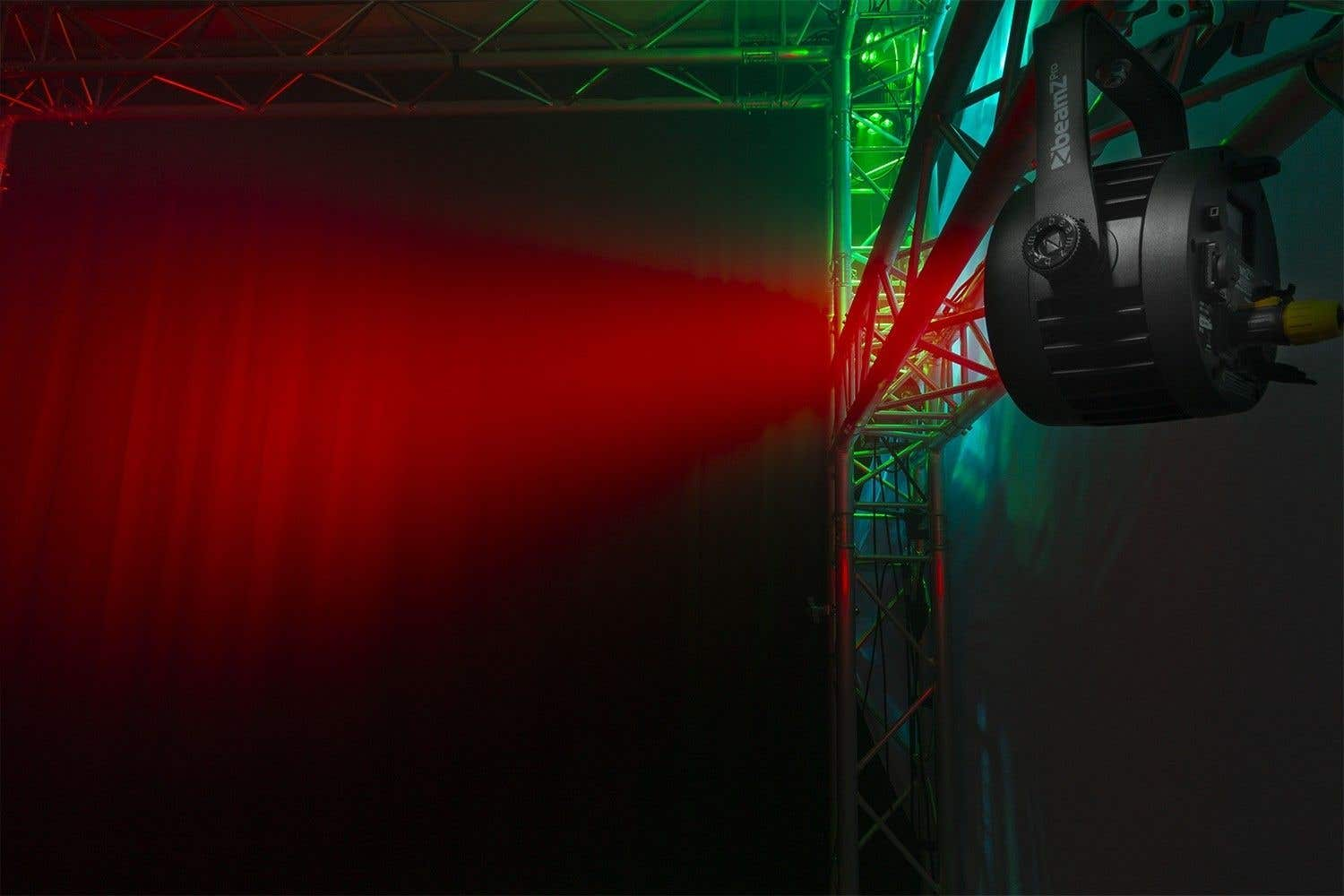 Configuración de iluminación de escenario con un haz rojo, luces verdes y azules y un foco negro.