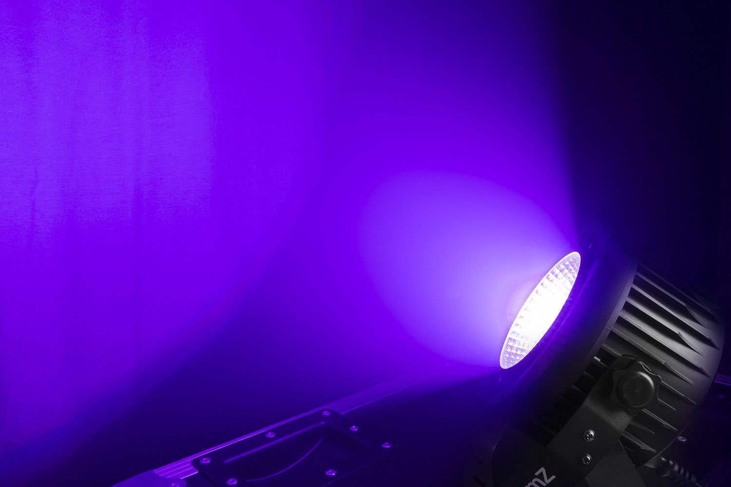 Un foco de escenario con LED blanco brillante, que emite un haz púrpura. Carcasa negra y fondo púrpura oscuro.