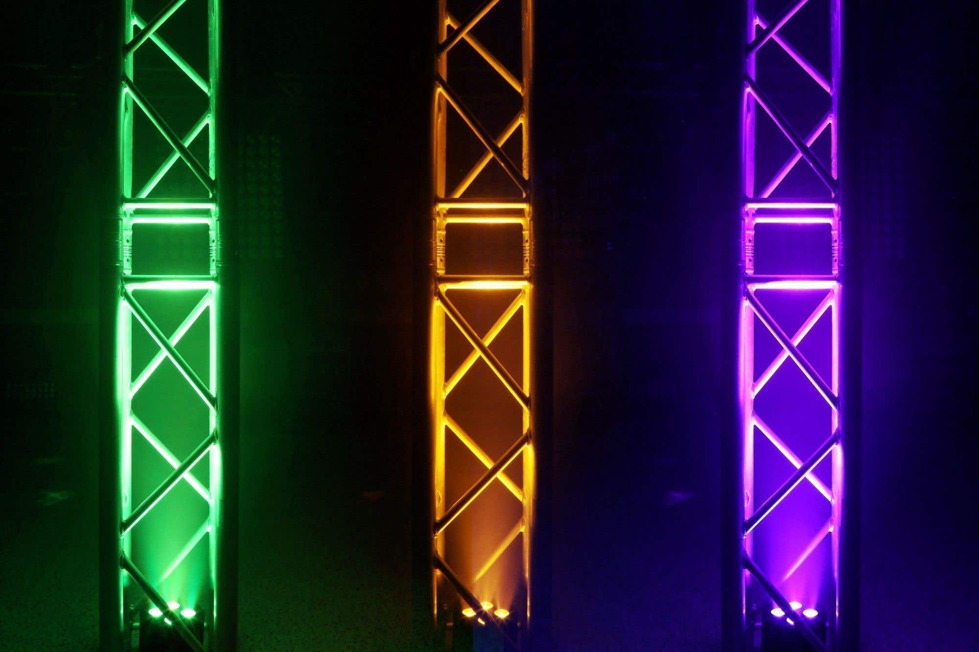 Tres estructuras metálicas iluminadas en verde, amarillo y morado sobre un fondo oscuro, cada una con un patrón de cruces diagonales.