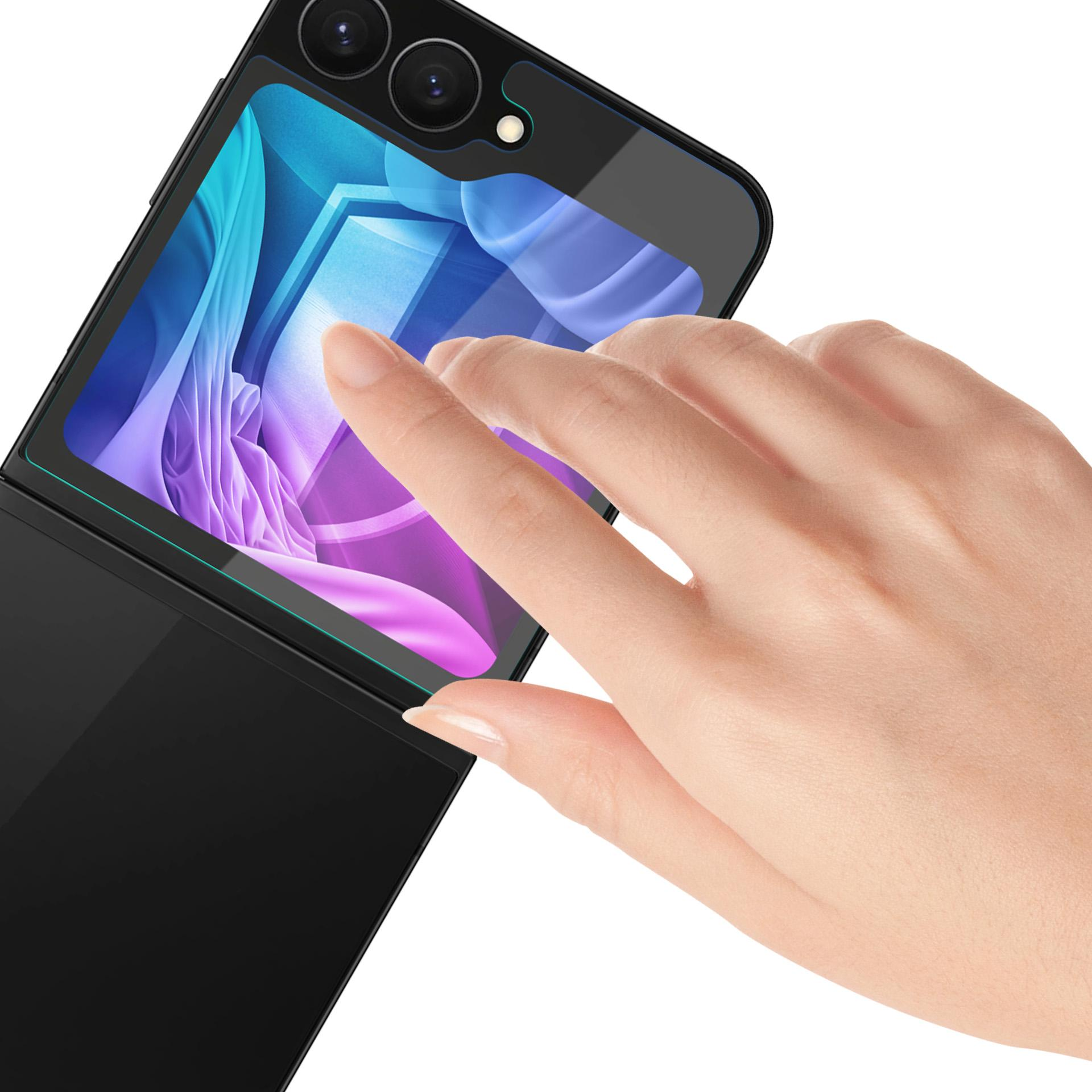Mano che tocca un telefono pieghevole nero. Lo schermo del telefono mostra un design astratto blu e viola. Sfondo bianco.