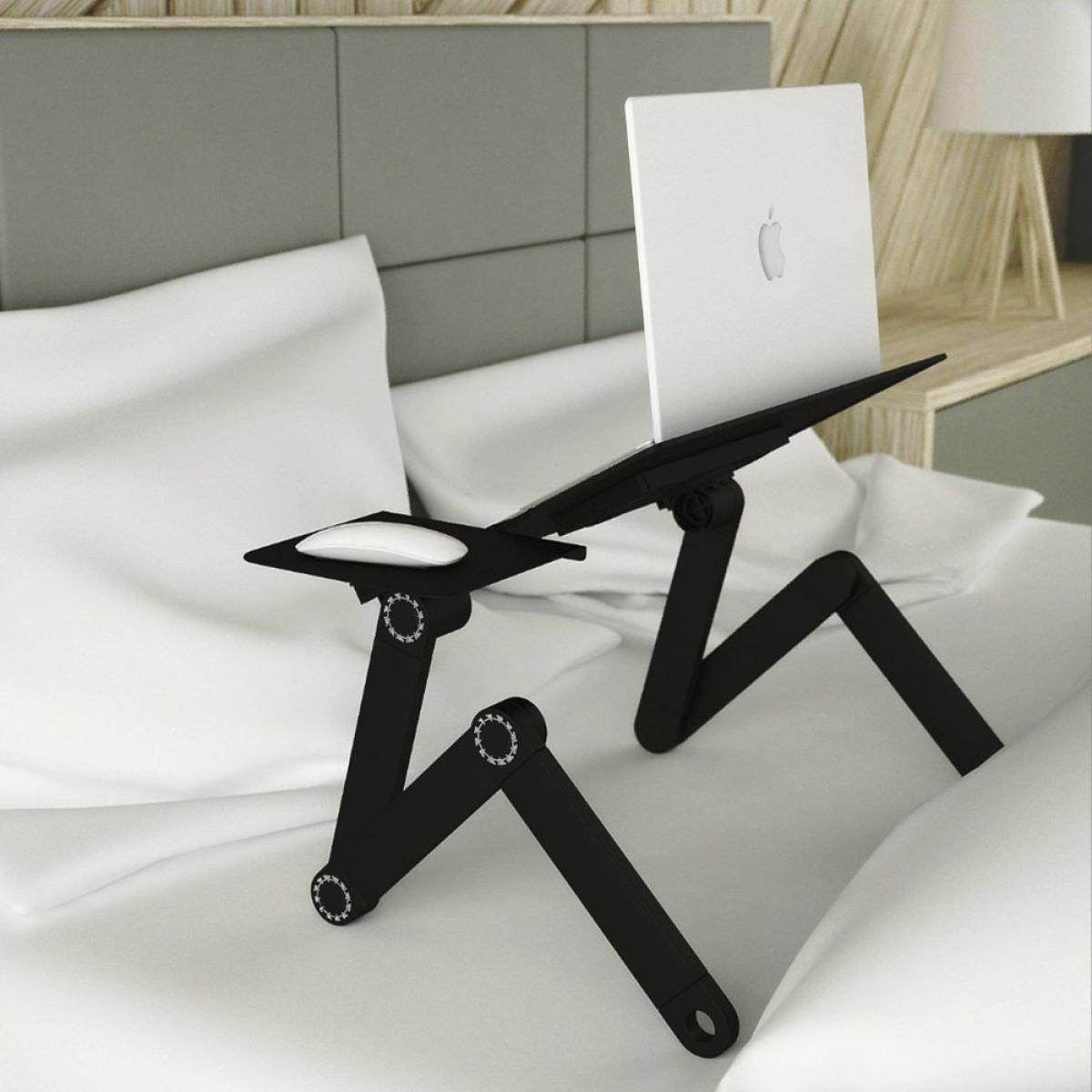 A black laptop stand with a white laptop and mouse on a bed with white sheets and pillows. Background is a headboard.