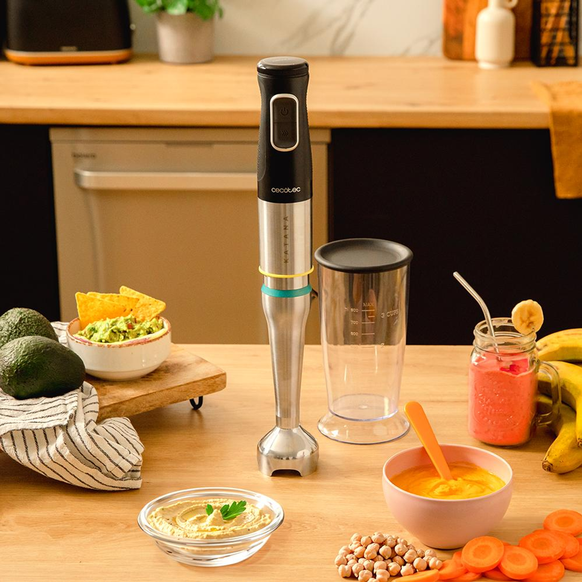 Scena kuchenna z blenderem, koktajlem, guacamole, hummusem, marchewką i bananami na drewnianej powierzchni.