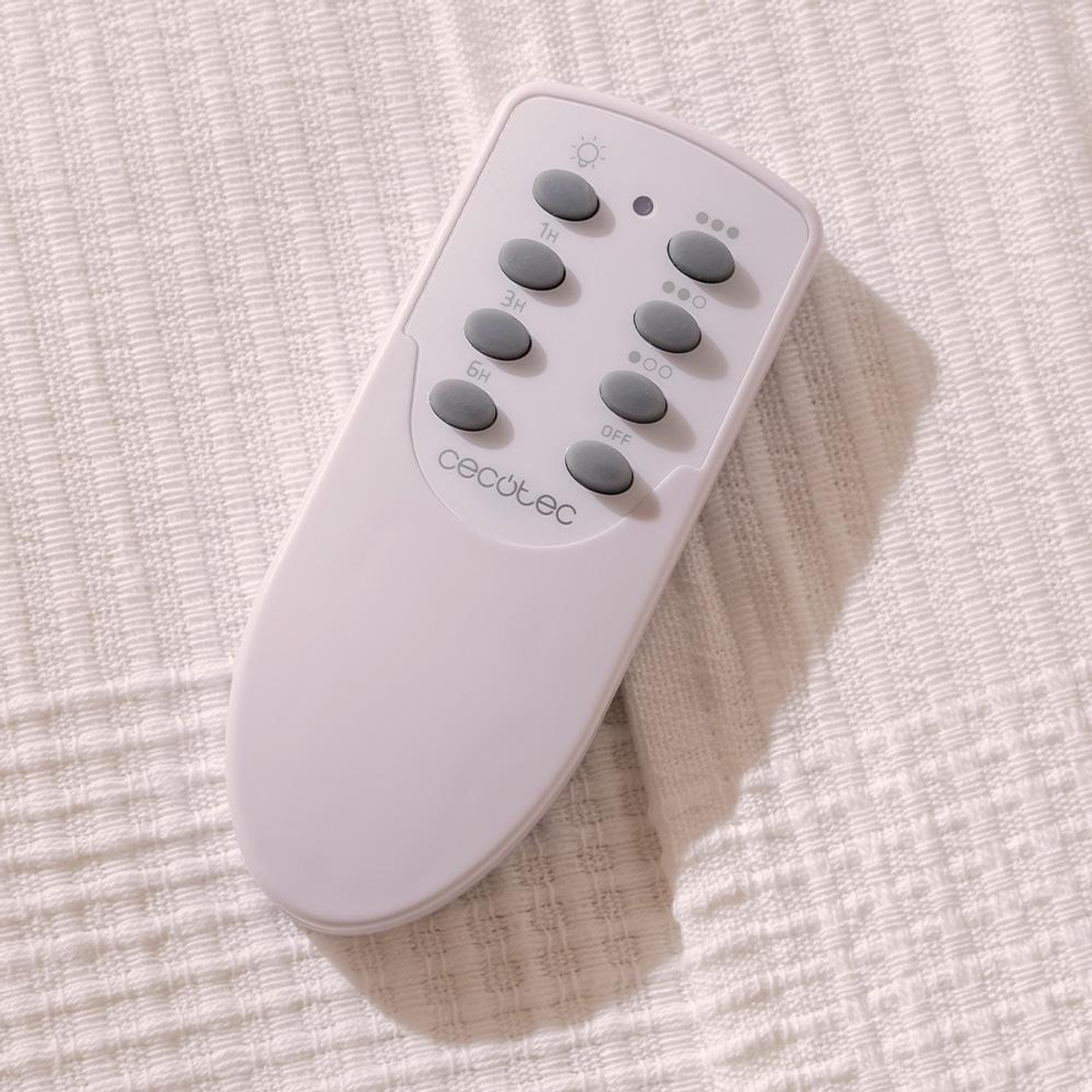 Biały pilot na białej, teksturowanej tkaninie. Pilot ma kilka szarych przycisków z etykietami. Marka to Cecotec.