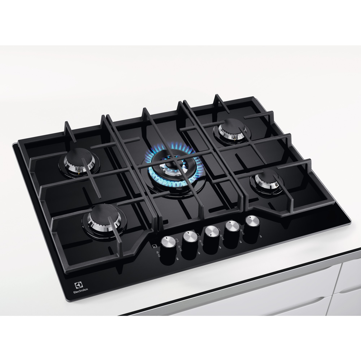 Schwarzes Gasherd mit fünf Brennern. Ein Brenner brennt mit blauen Flammen. Knöpfe sind sichtbar. Electrolux-Logo in der Ecke.