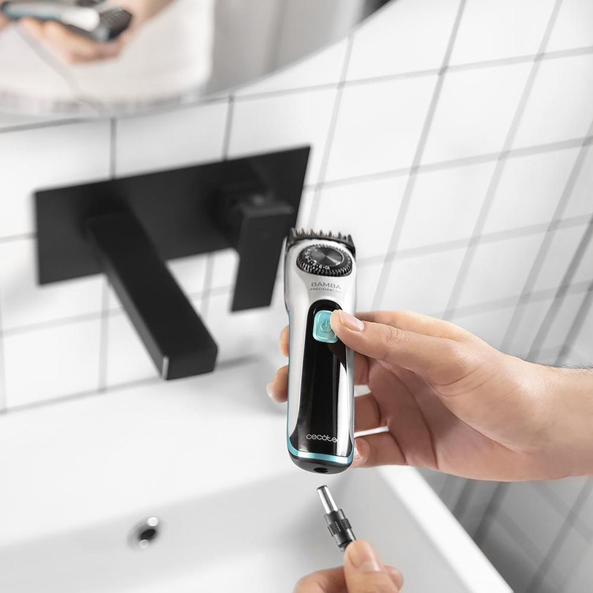 Una persona tiene in mano un trimmer di precisione Bamba. Sullo sfondo un rubinetto nero e un lavandino bianco, con piastrelle bianche.