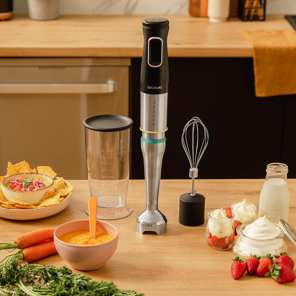 Scena kuchenna z blenderem, miską zupy, chipsami, truskawkami i śmietaną na drewnianej powierzchni.