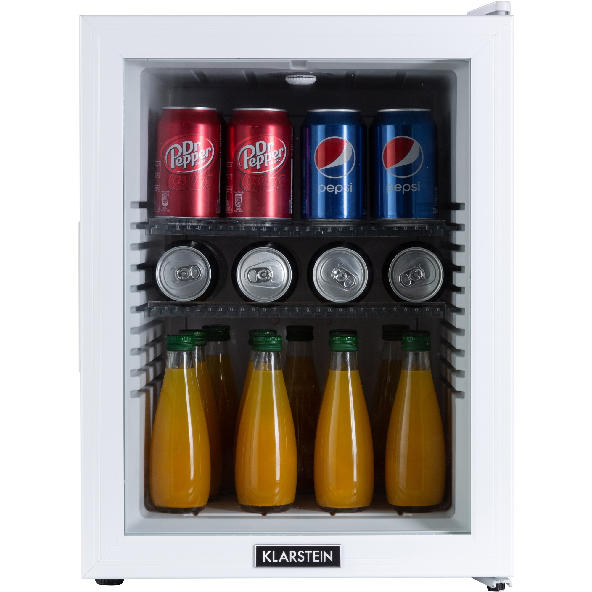 Una mini nevera blanca con latas de Dr. Pepper y Pepsi, y botellas de jugo. La marca es Klarstein.