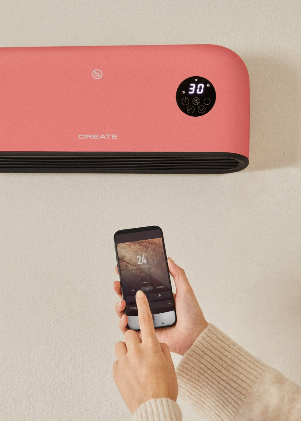 Una persona usa un teléfono para controlar un calefactor de pared rosa. El calefactor muestra 30 grados. El teléfono muestra 24 grados.