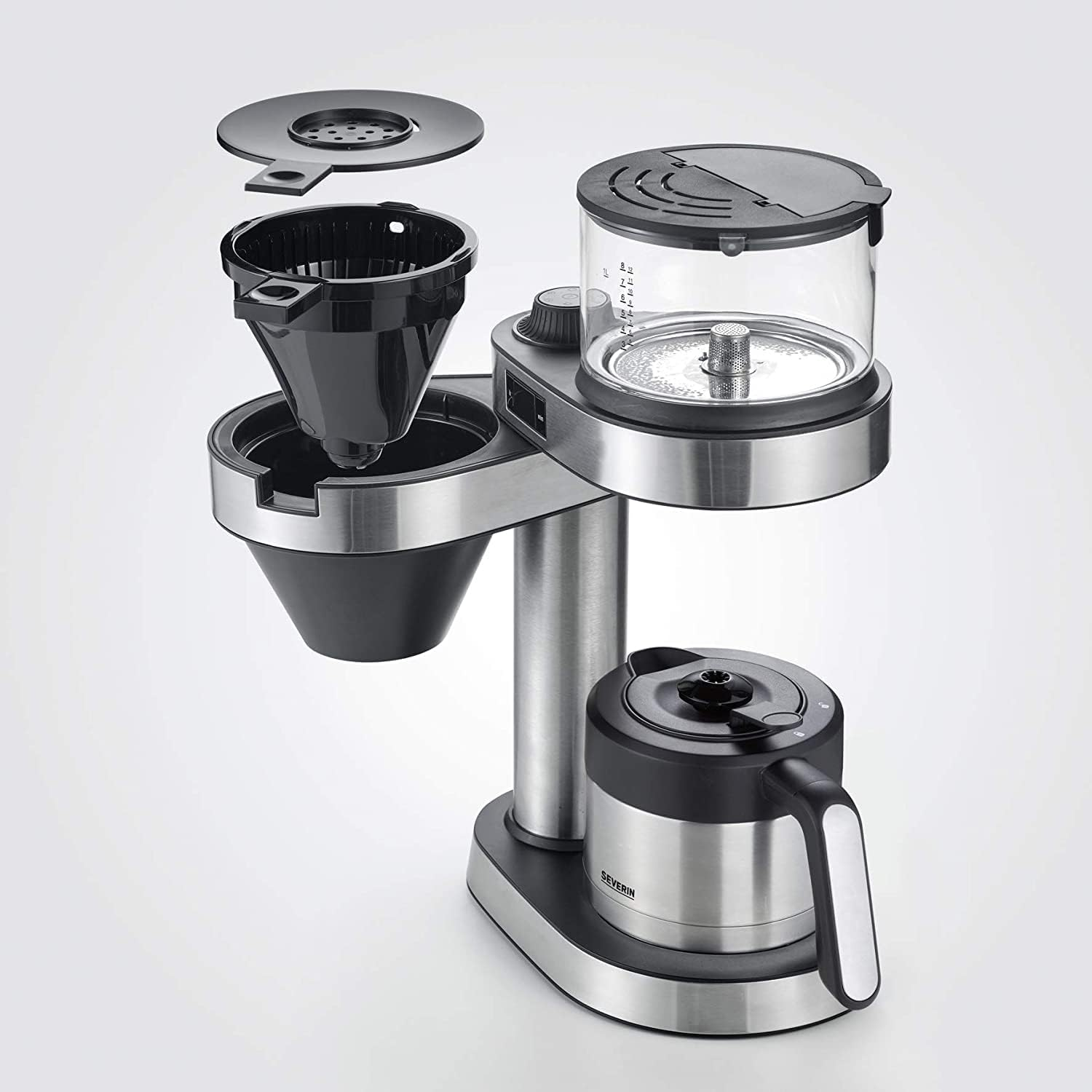 Kaffeemaschine zerlegt: schwarzer Filter, klarer Wasserbehälter, silberne Basis, schwarze Karaffe mit Griff, Edelstahldetails.