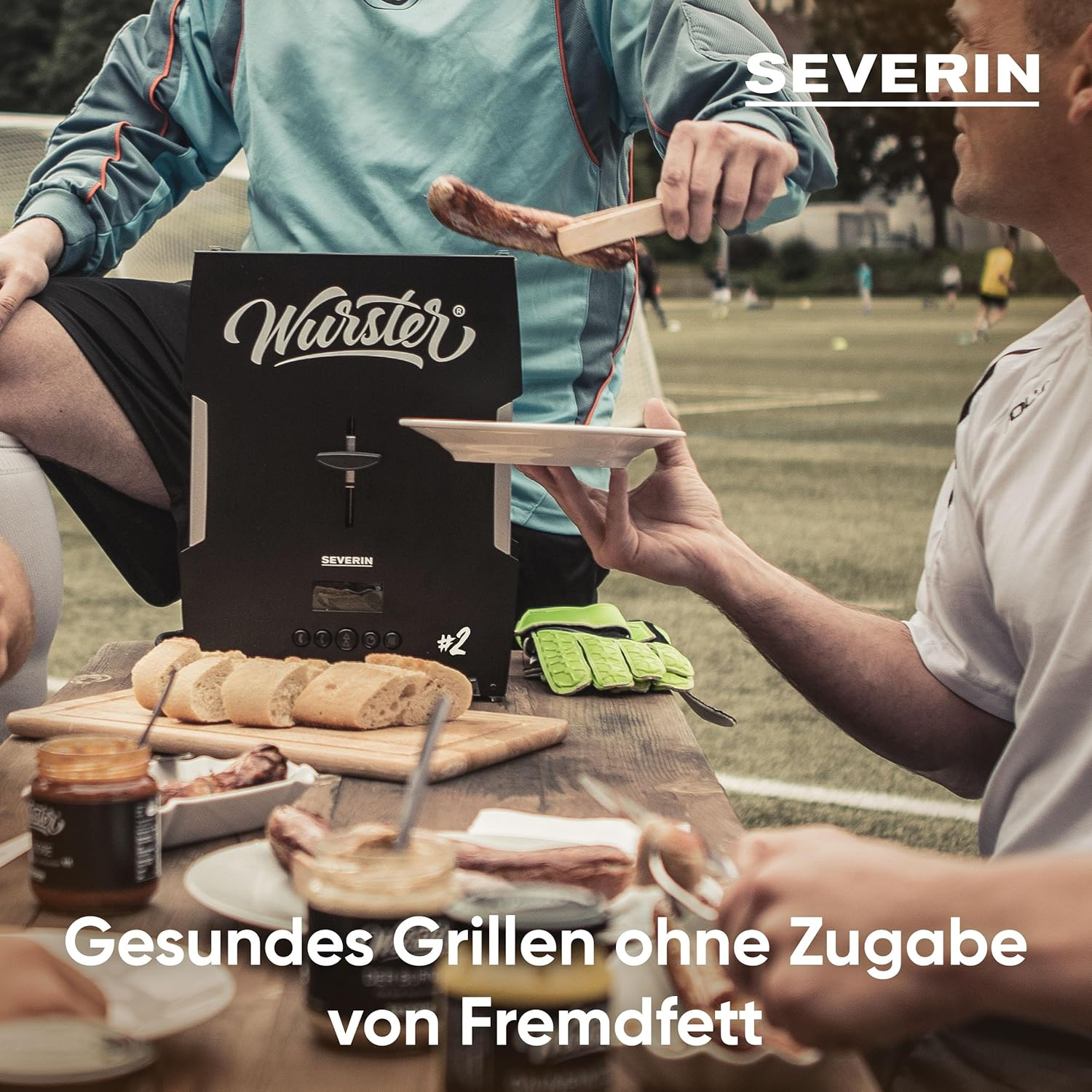 A person grilling a sausage. The scene includes a grill, bread, condiments, and people. Text at the bottom: Gesundes Grillen ohne Zugabe von Fremdfett.
