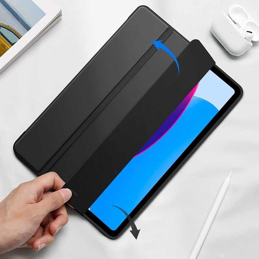 Schwarzes Tablet mit geöffneter Hülle, das einen blau-violetten Bildschirm zeigt. Hand öffnet die Abdeckung. Weiße Accessoires im Hintergrund.