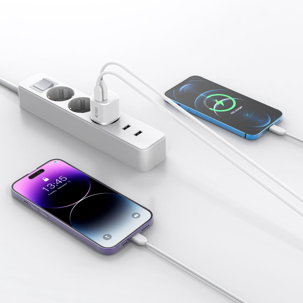 Zwei Smartphones laden, eines blau, eines lila. Weiße Steckdosenleiste mit angeschlossenem Ladegerät. Telefone zeigen Ladestatus.