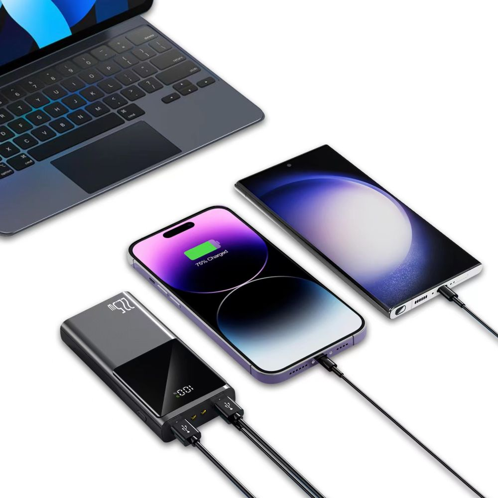 Un ordinateur portable et deux smartphones sont chargés par une batterie externe. Un téléphone affiche 75% de charge. Des câbles relient tous les appareils.