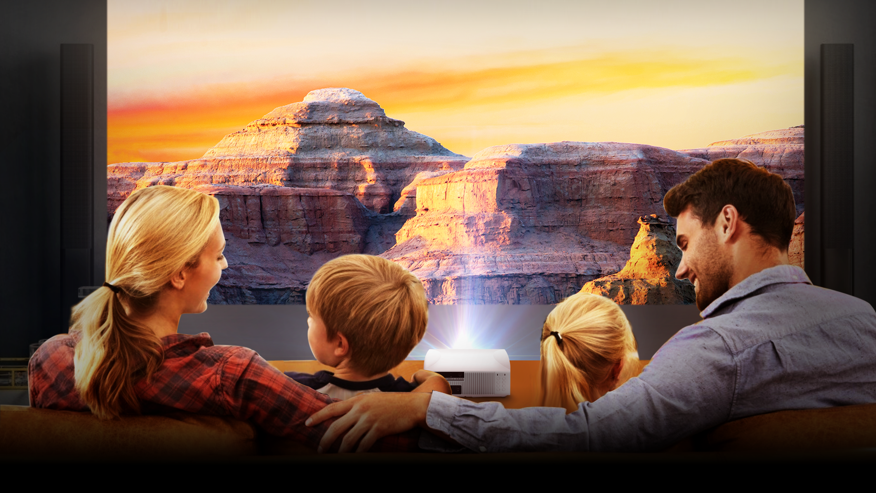 Familie sieht sich ein projiziertes Landschaftsbild an. Ein Projektor steht auf einem Tisch. Der Sonnenuntergang ist zu sehen.