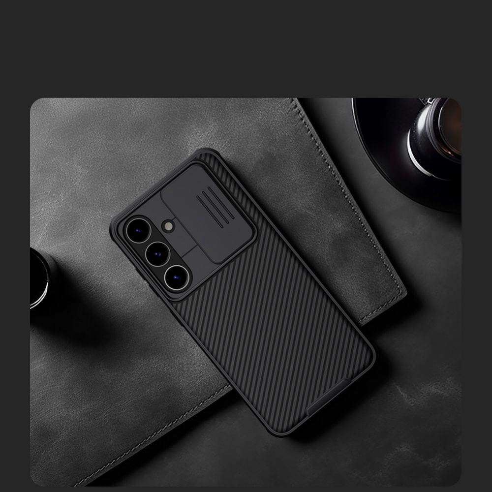 Una custodia nera per telefono con protezione fotocamera, posizionata su una superficie in pelle scura. Sono visibili anche una tazza di caffè e una tazzina.