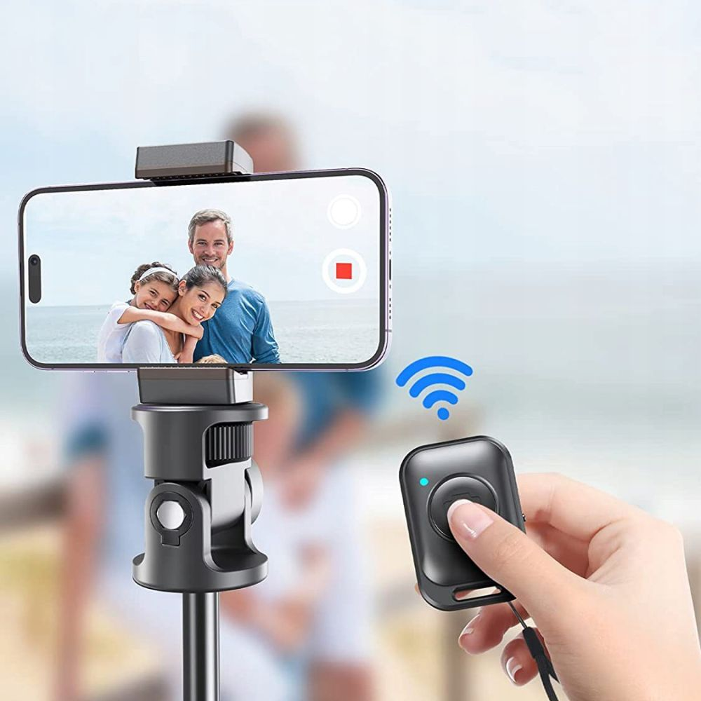 Een telefoon op een statief neemt een gezin op. Een hand houdt een afstandsbediening met blauw licht en wifi-symbool vast. Een persoon staat op de achtergrond.