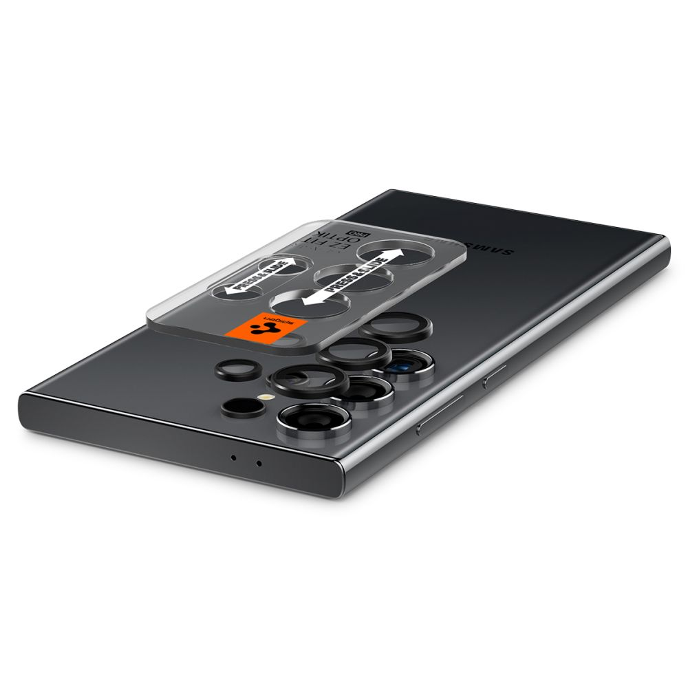 Telefon z przezroczystą osłoną obiektywu na górze. Ochraniacz ma strzałki i tekst, telefon jest szary i ma wiele obiektywów.