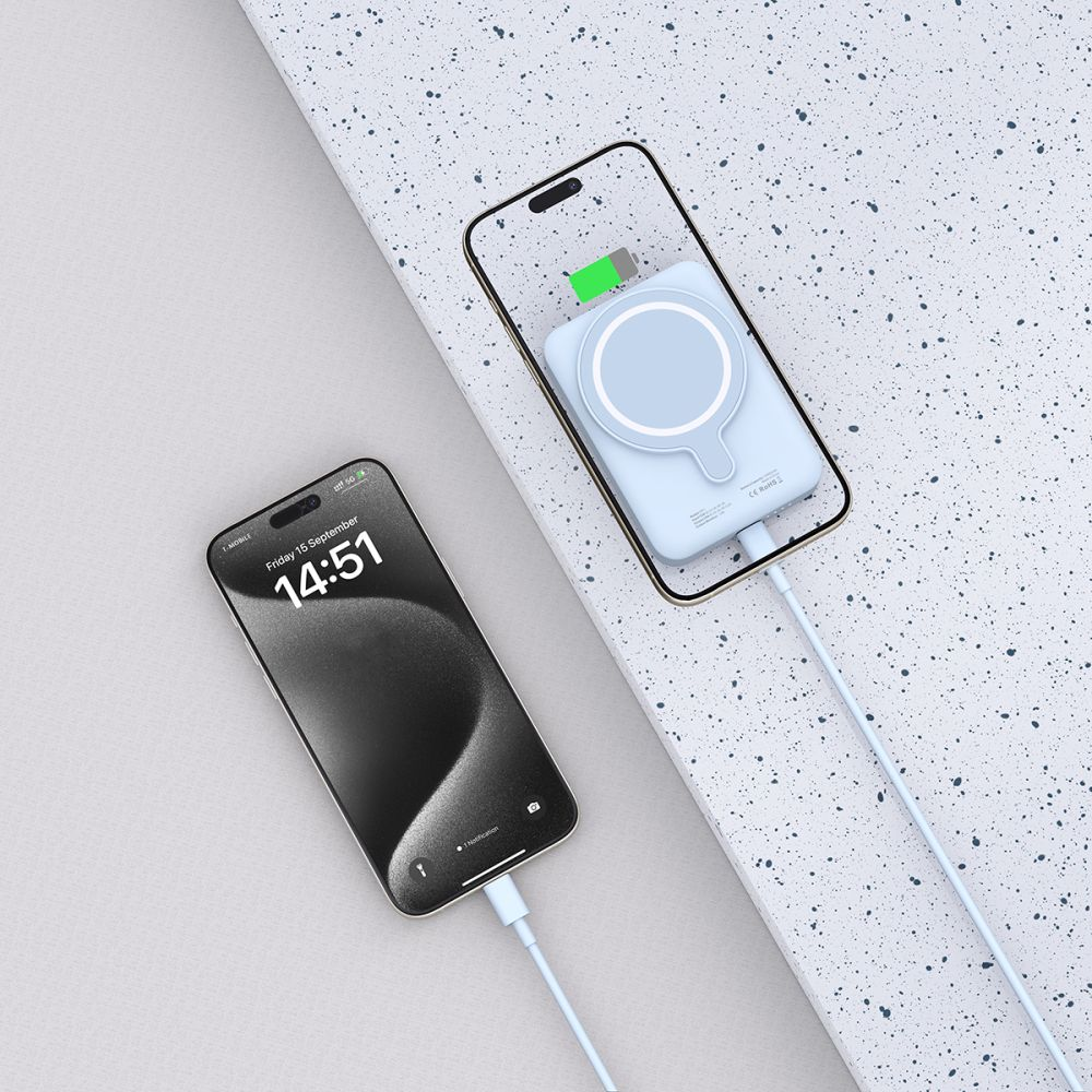 Deux smartphones, l'un se charge sans fil. Un téléphone affiche l'heure, l'autre a un indicateur de charge. Les deux ont des câbles blancs.