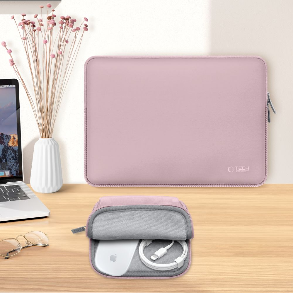 Een roze laptoptas en een kleinere etui met een muis en kabel op een houten tafel. Een vaas met gedroogde bloemen aan de linkerkant.