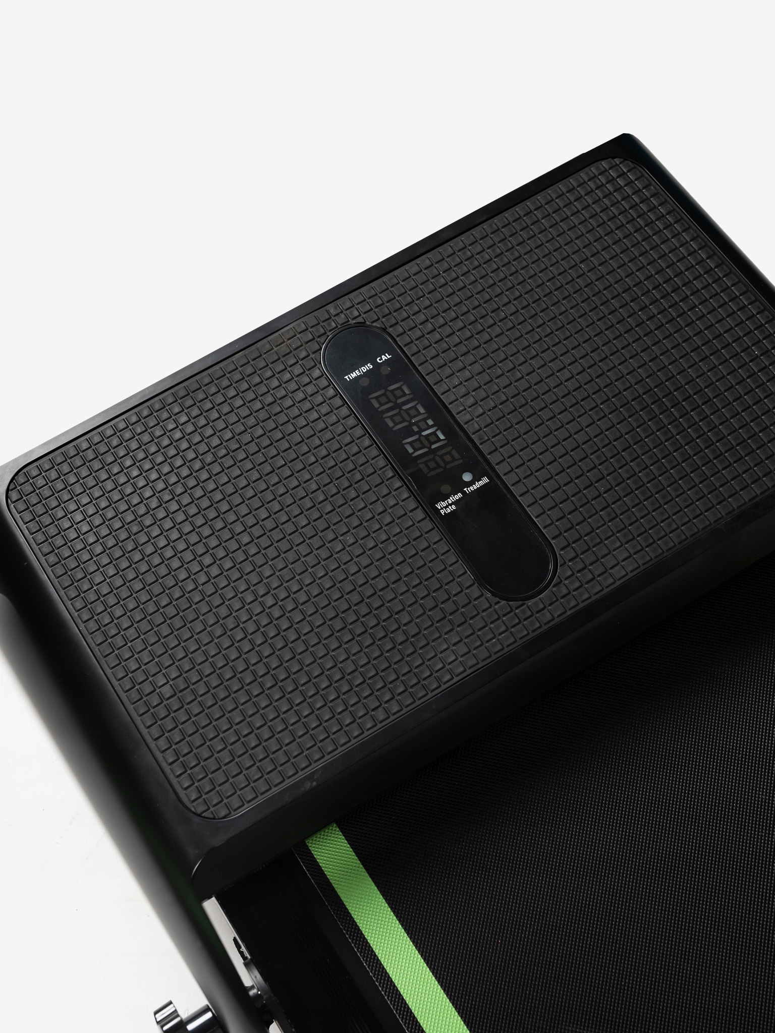 Czarna bieżnia z cyfrowym wyświetlaczem. Ma teksturowaną powierzchnię z widocznymi zielonymi paskami.