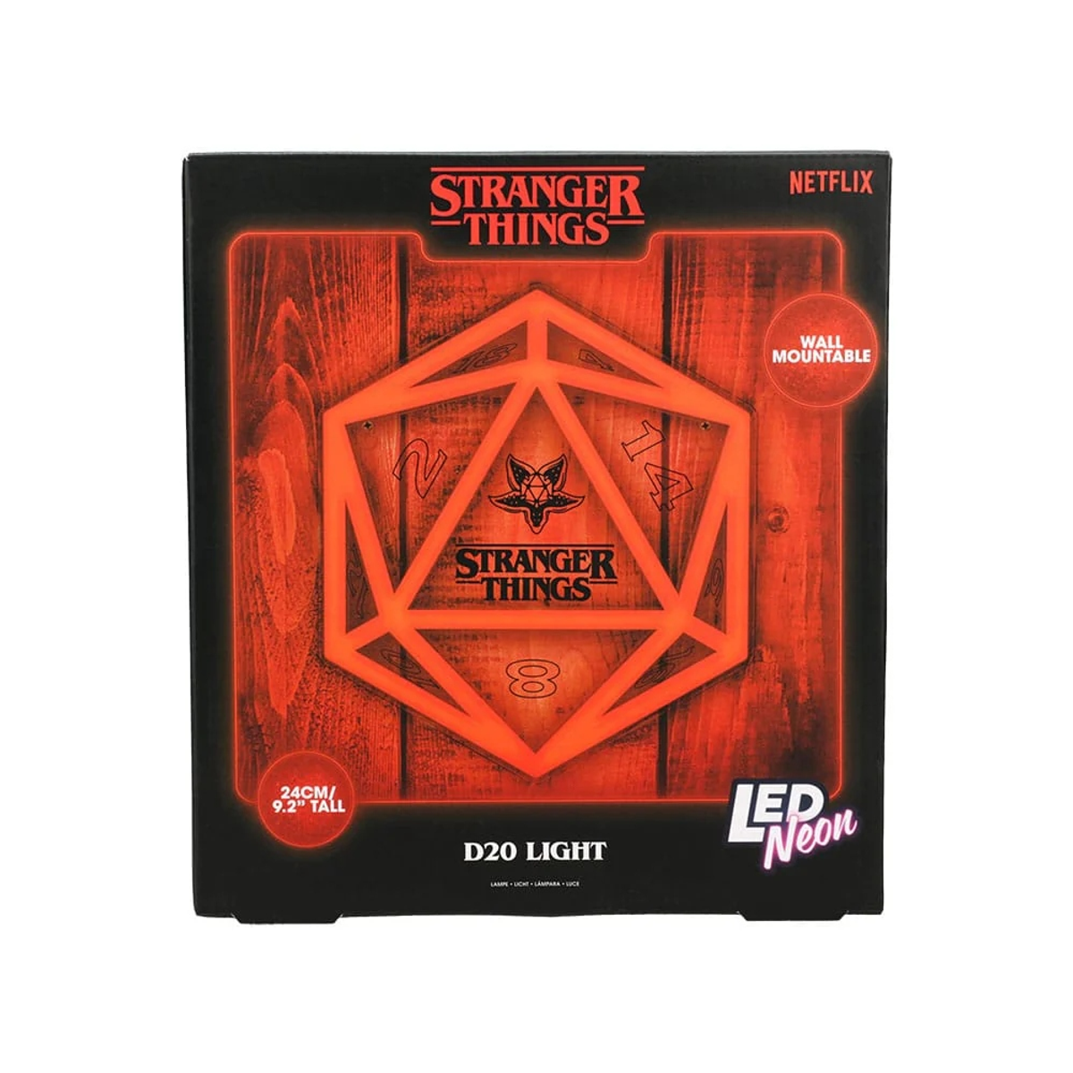 Światło neonowe LED D20 Stranger Things w pudełku, z logo serialu i drewnianym tłem.