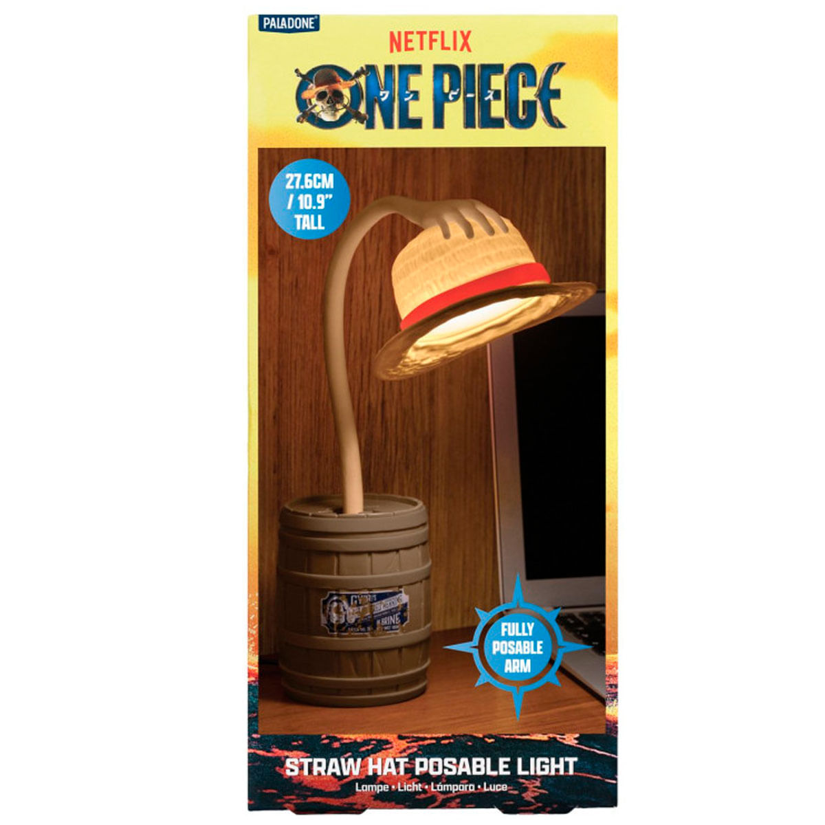 Una lámpara de sombrero de paja de One Piece. La lámpara tiene una base de barril, un brazo articulado y una lámpara con forma de sombrero. Hay un portátil.