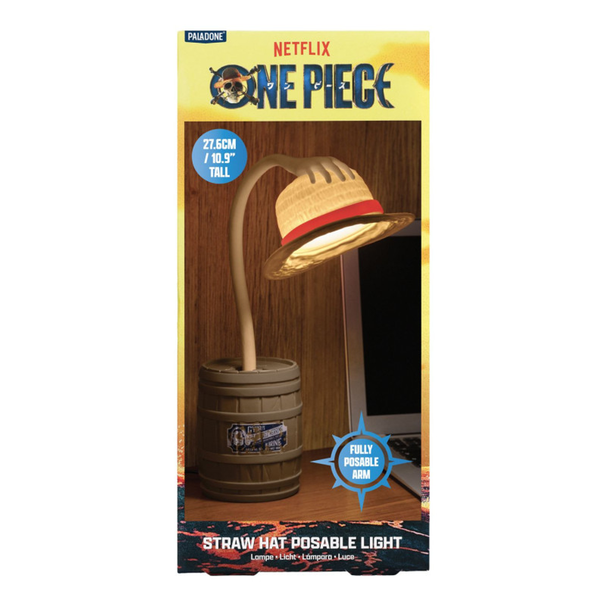 Una lámpara de sombrero de paja de One Piece con base de barril. La lámpara está en un escritorio con una computadora portátil. El fondo es una pared de madera.