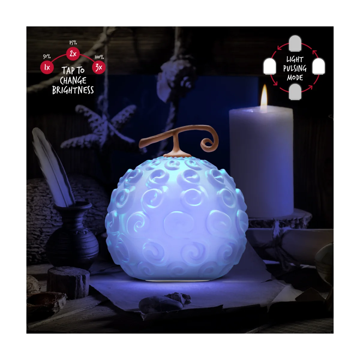 Una lámpara con forma de fruta azul brillante está sobre una mesa. También hay una vela y una pluma en la mesa.