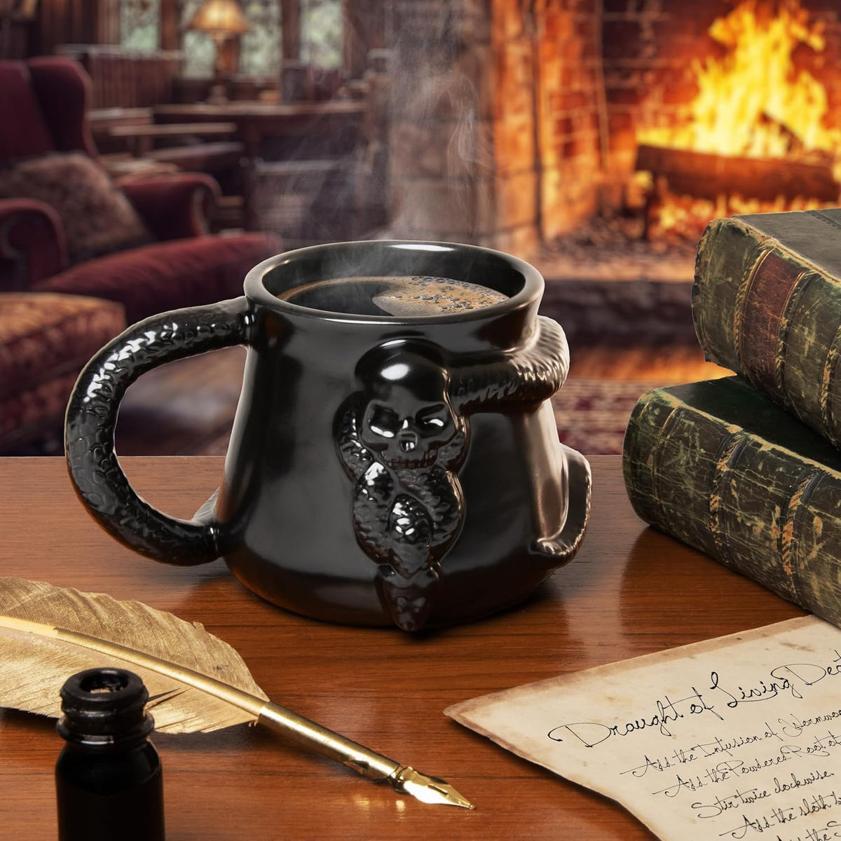 Una taza negra en forma de caldero con un diseño de calavera y serpiente, café humeante, junto a libros antiguos, una pluma y un tintero.