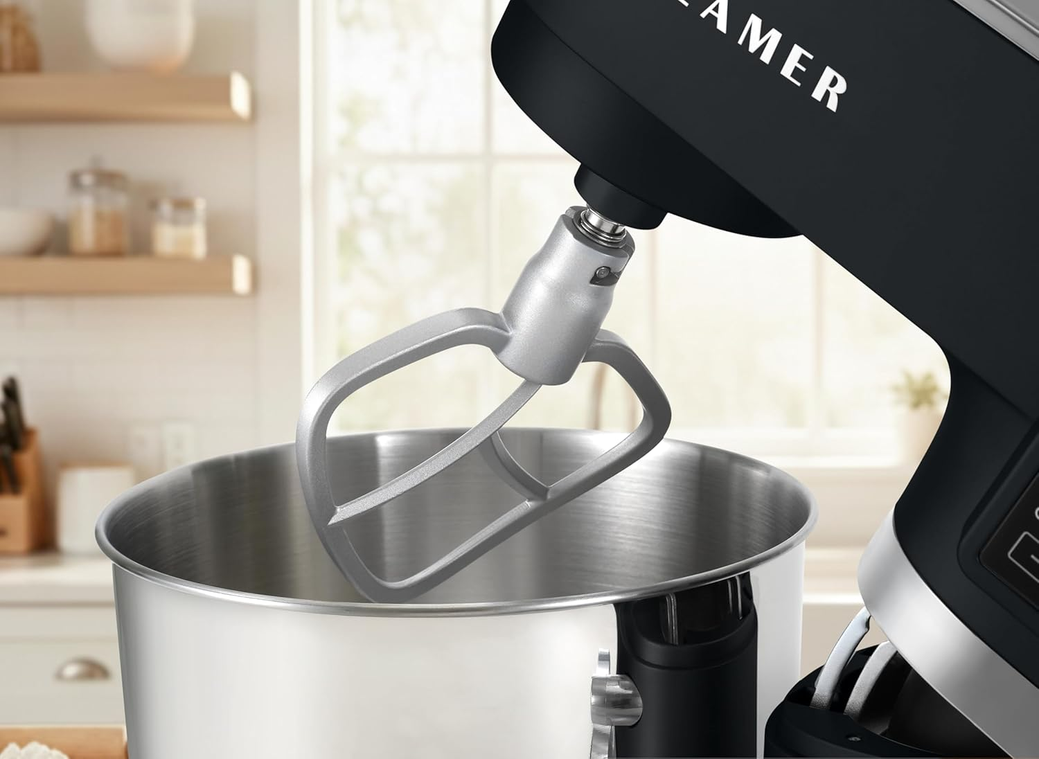 Nahaufnahme eines Küchenmixers. Der Mixer ist schwarz und silber, mit einer Edelstahlschüssel und einem Rührbesen.