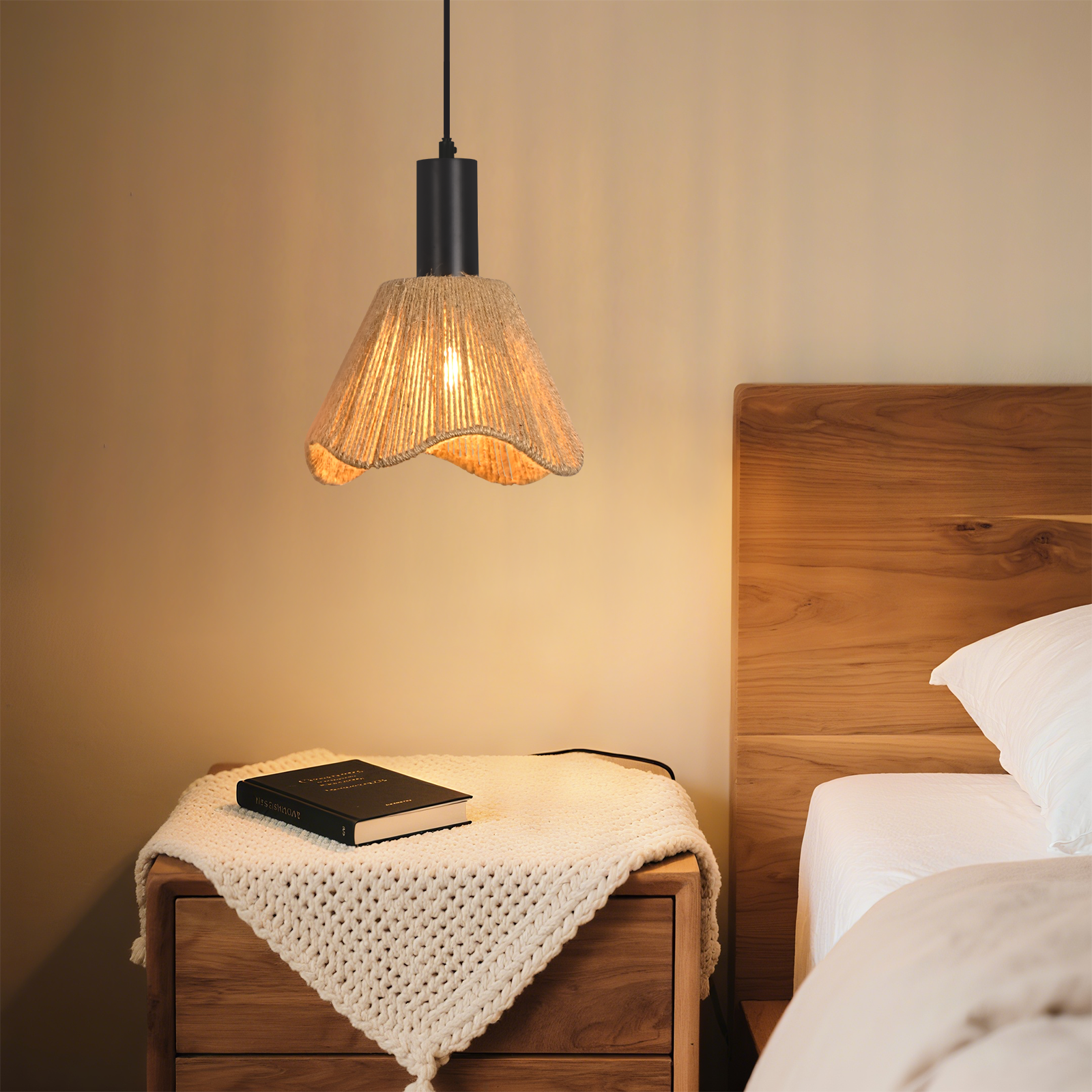 Scena sypialni: lampa wisząca, książka na szafce nocnej i łóżko. Lampa ma abażur z liny. Pokój jest ciepło oświetlony.