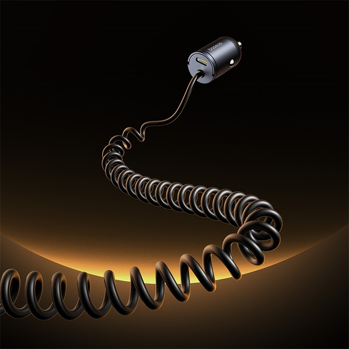 Caricabatterie per auto nero con cavo a spirale. Il caricatore è cilindrico con porta USB. Sfondo scuro con sfumatura oro.