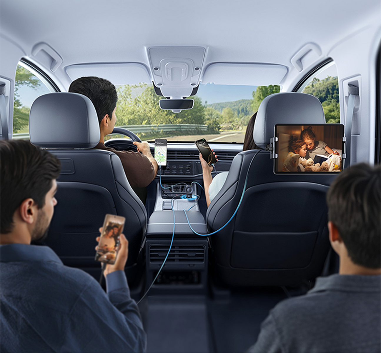 Dentro de un coche, cuatro personas usan teléfonos y una tableta. El conductor navega. Una pantalla trasera muestra niños leyendo.