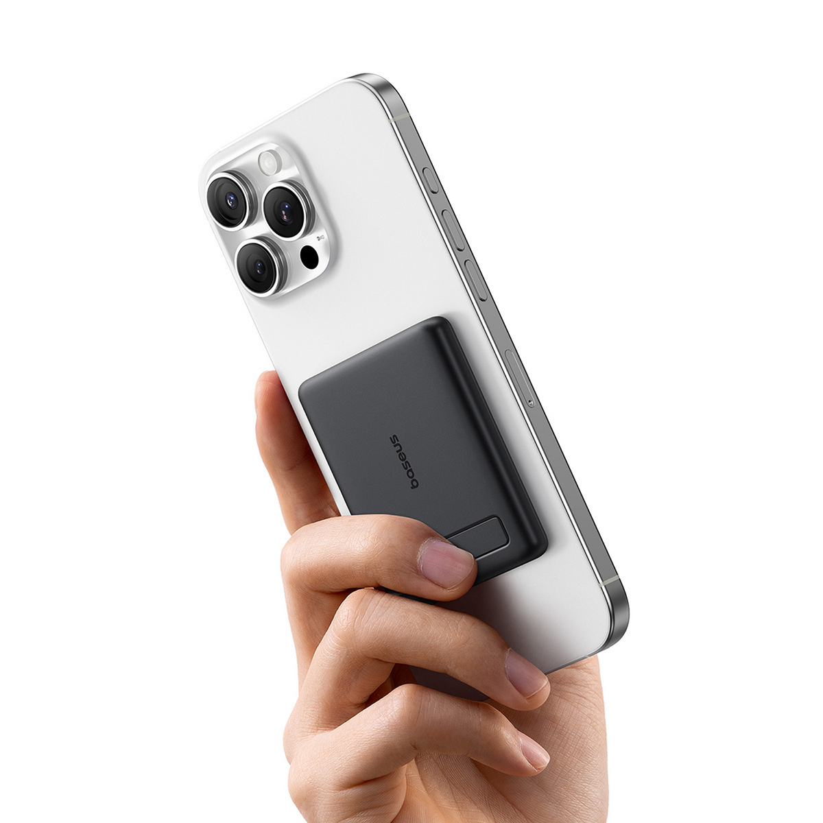 Una mano tiene un telefono bianco con un power bank nero attaccato. Il telefono ha tre fotocamere. Il power bank ha il logo Baseus.