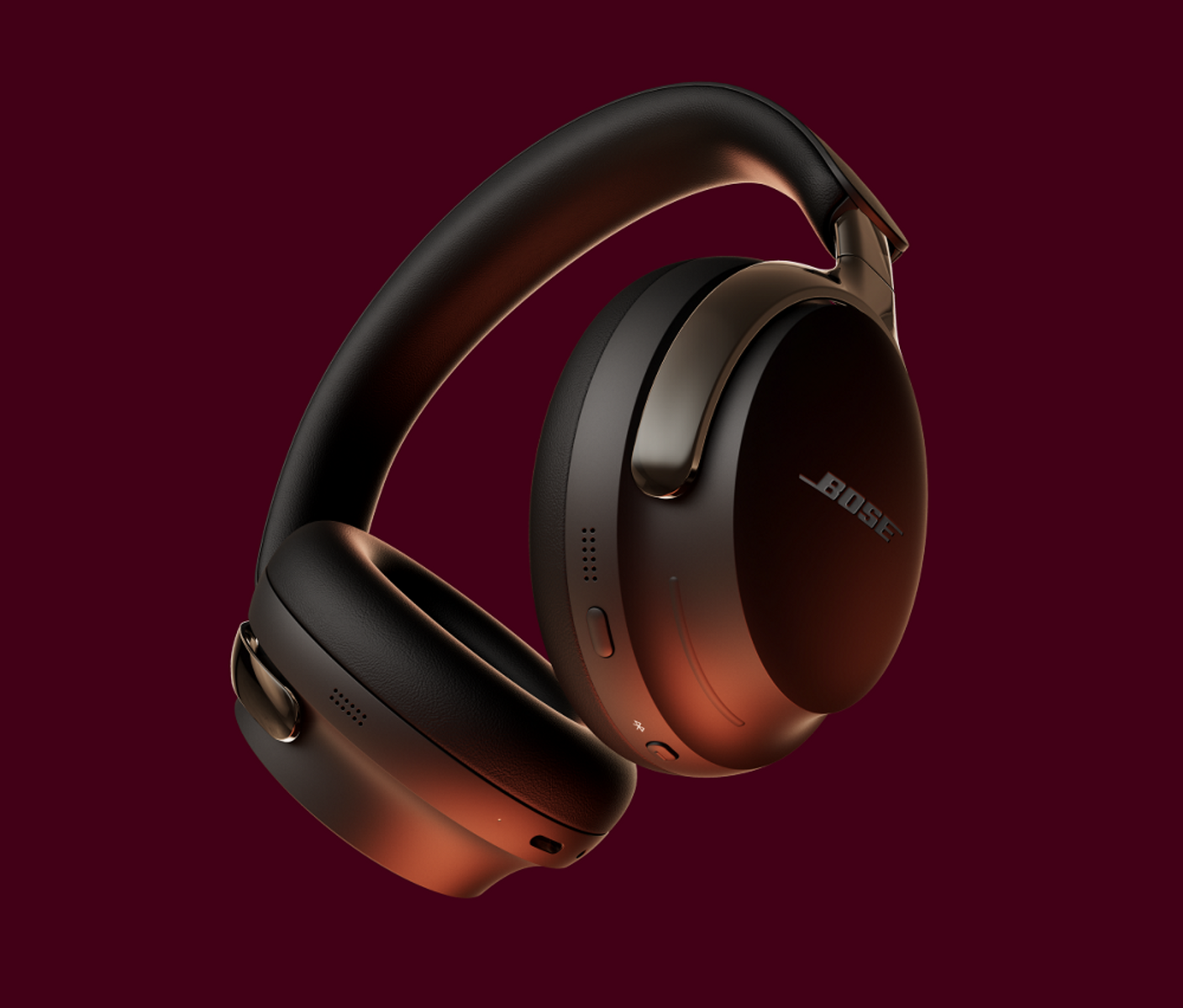 Para czarnych słuchawek Bose na bordowym tle. Słuchawki mają teksturowane wykończenie i logo.