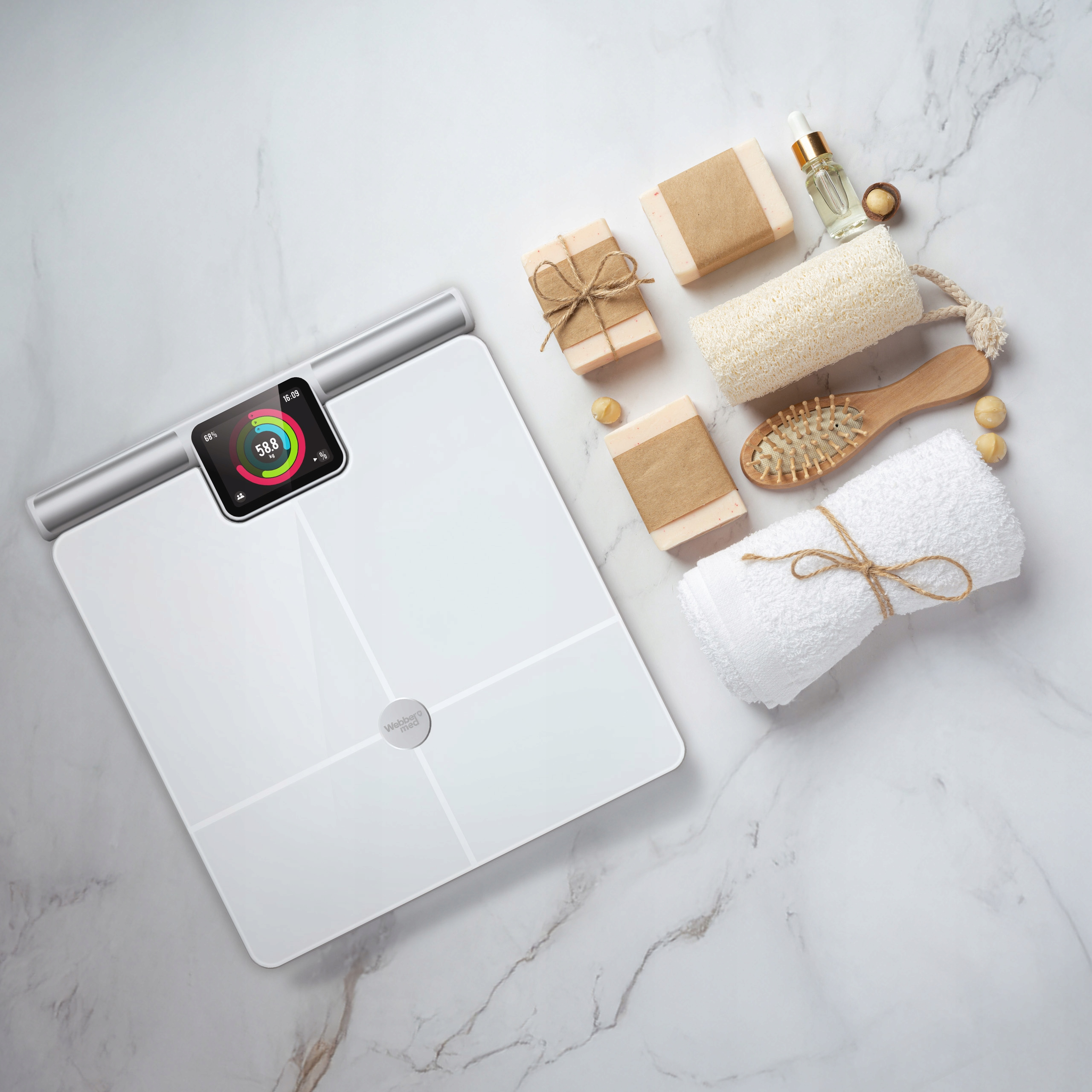 Biała waga z wyświetlaczem, mydło, szczotka, olejek i ręcznik na marmurze. Waga pokazuje statystyki.
