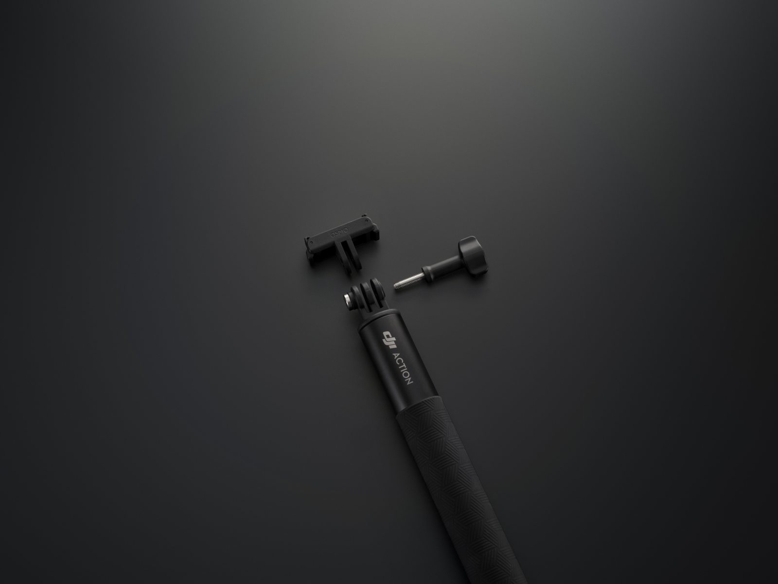 Accesorios negros para cámara DJI Action sobre una superficie oscura. Incluye mango, soporte y tornillo, todos separados.