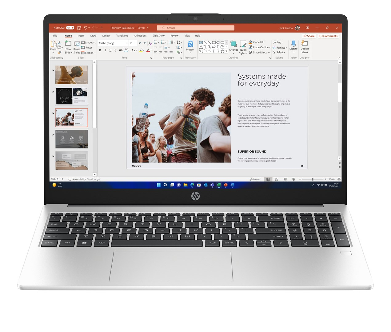 Laptop pokazujący prezentację ze zdjęciem ludzi. Logo HP na dole. Klawiatura widoczna.