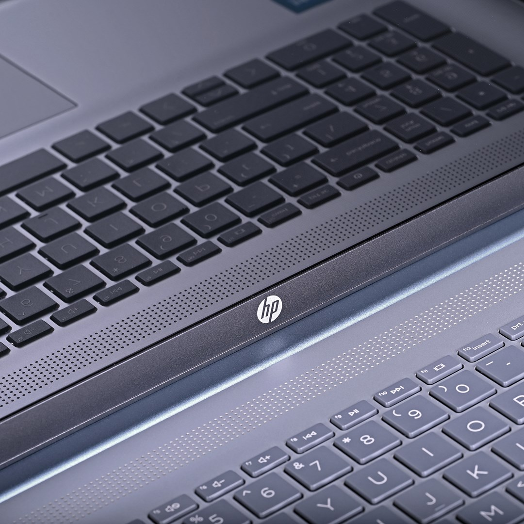 Zbliżenie dwóch klawiatur laptopów. Jedna jest w większości widoczna z klawiszami, druga częściowo. Logo HP jest wyraźne.