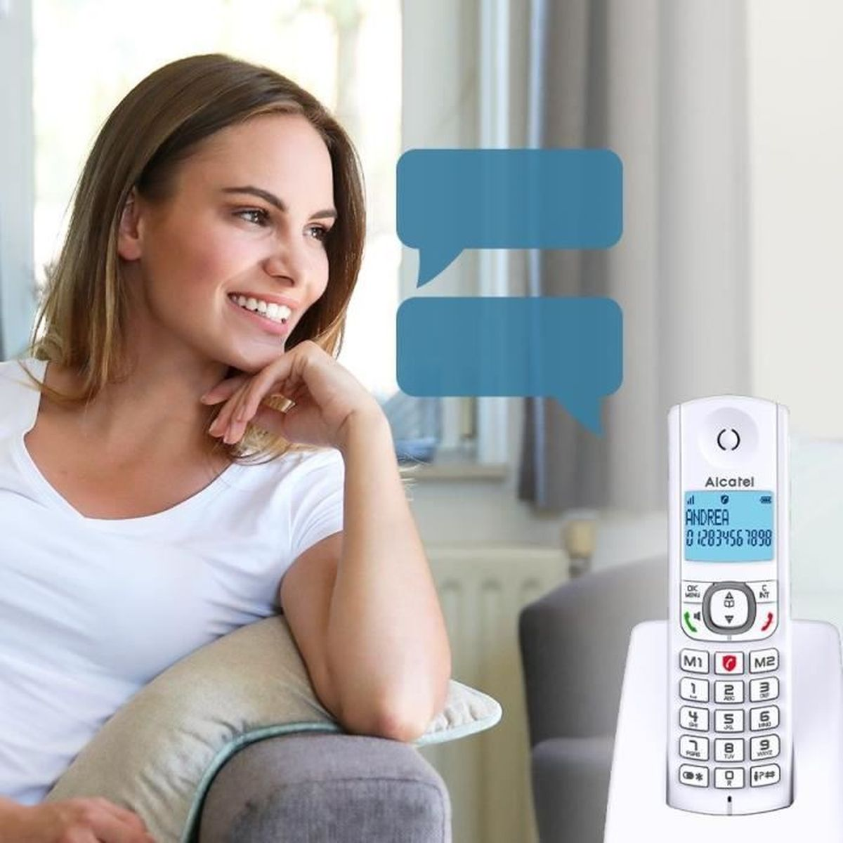 Una donna sorride, seduta su un divano. Un telefono cordless è vicino con uno schermo che mostra un nome e un numero.