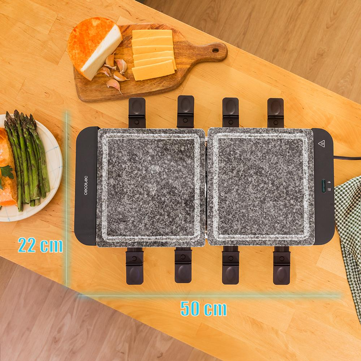 Grill do raclette z serem, szparagami i czosnkiem. Wymiary to 22 cm x 50 cm, na drewnianej powierzchni.