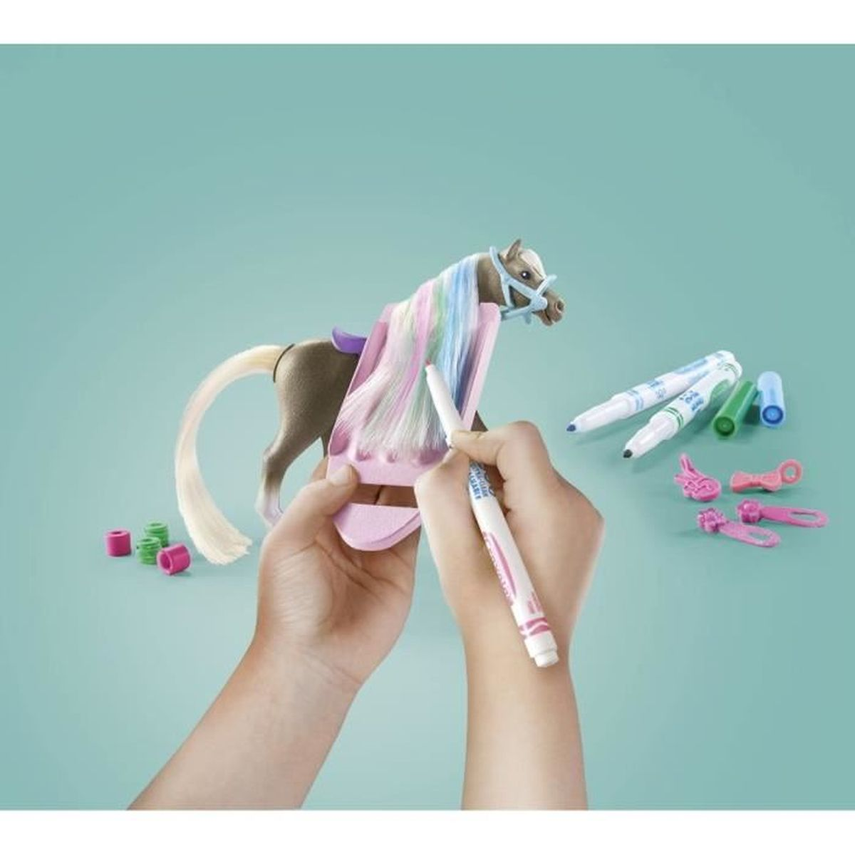 Una persona sta colorando i capelli di un cavallo giocattolo con un pennarello. Altri pennarelli e accessori per cavalli su sfondo turchese.