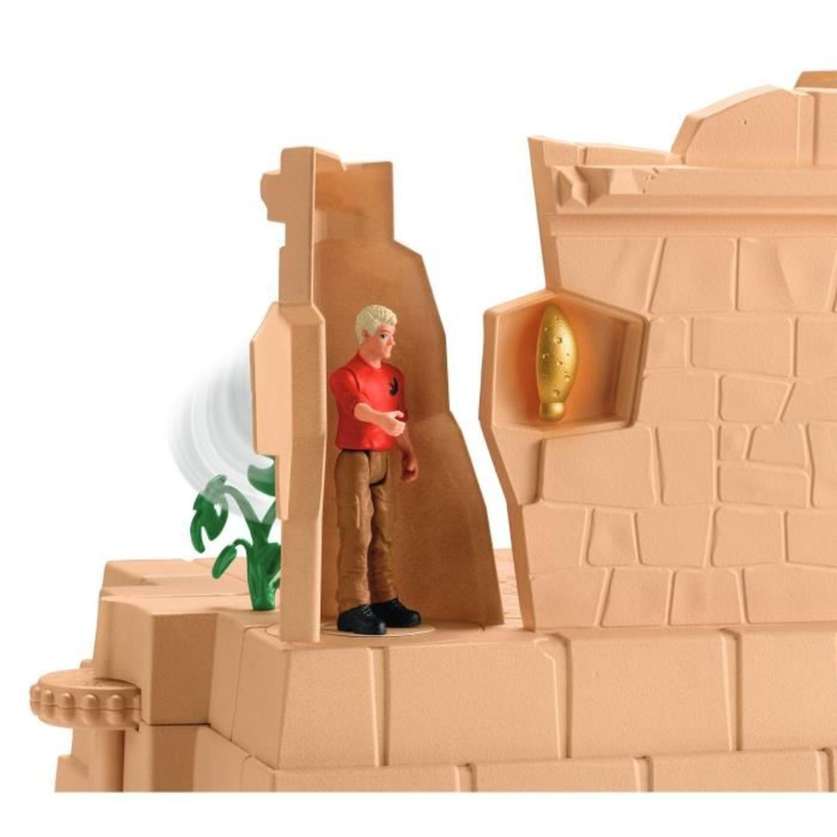 Eine Spielfigur in einem roten Hemd und einer braunen Hose steht in einer beigefarbenen Struktur. Ein goldenes Objekt befindet sich in einer Wand. Grüne Pflanzen sind links.