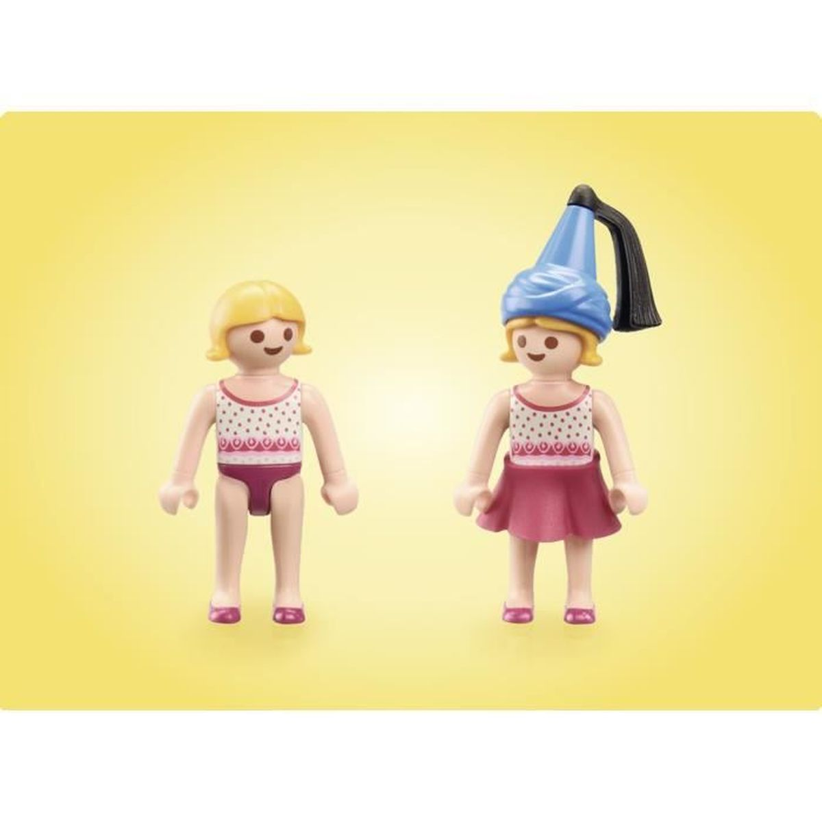 Zwei Playmobil-Figuren. Eine trägt einen Badeanzug, die andere ein Kleid und einen Hut. Beide haben blondes Haar und stehen auf gelbem Grund.