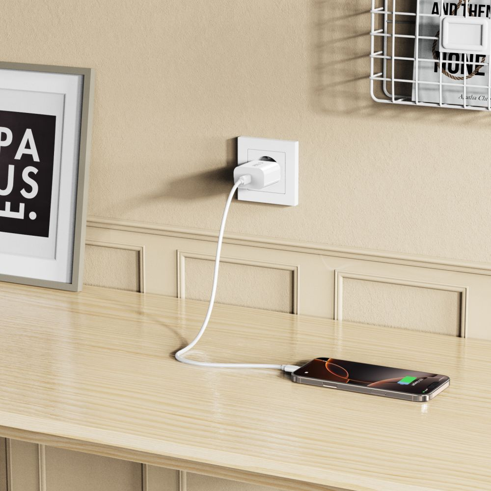 Ein Telefon, das auf einem Holztisch aufgeladen wird. Ein weißes Ladegerät ist an der Wand eingesteckt und mit dem Telefon verbunden.