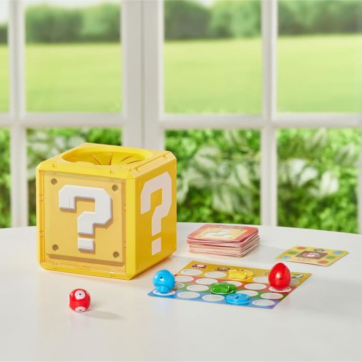 Gele vraagtekenblok, spelstukken, kaarten en bord op een witte tafel. Een raam met groen uitzicht op de achtergrond.