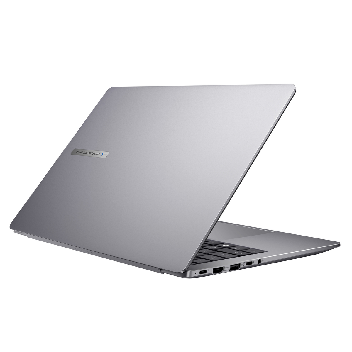 Un portátil Asus ExpertBook plateado está abierto sobre un fondo blanco. El teclado es negro. La pantalla está abierta.