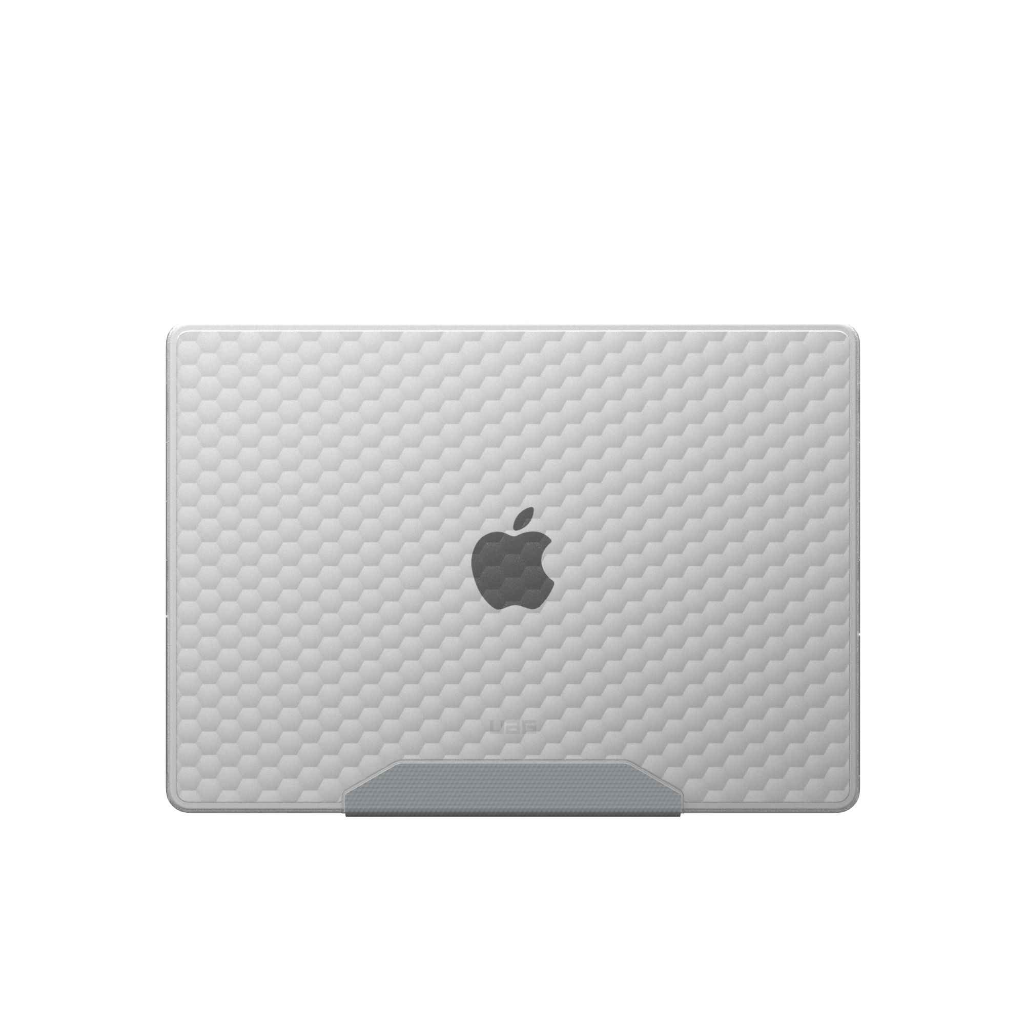 Szary laptop z wzorem plastra miodu i logo Apple na białym tle, trzymany przez szarą podstawkę.