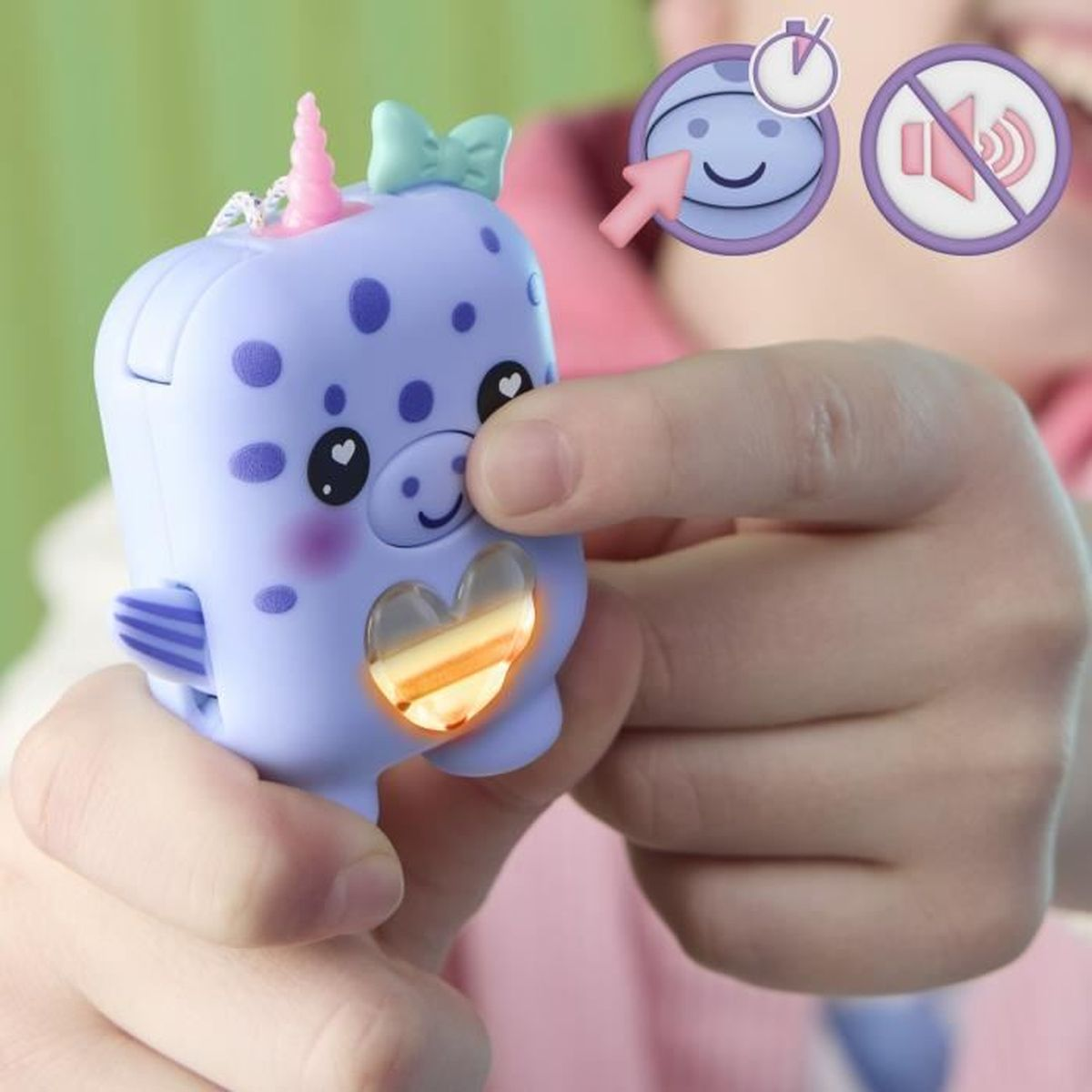 Die Hand eines Kindes hält ein lila Spielzeug-Narwal mit einem rosa Horn und einem herzförmigen Licht. Oben ist eine Schleife.