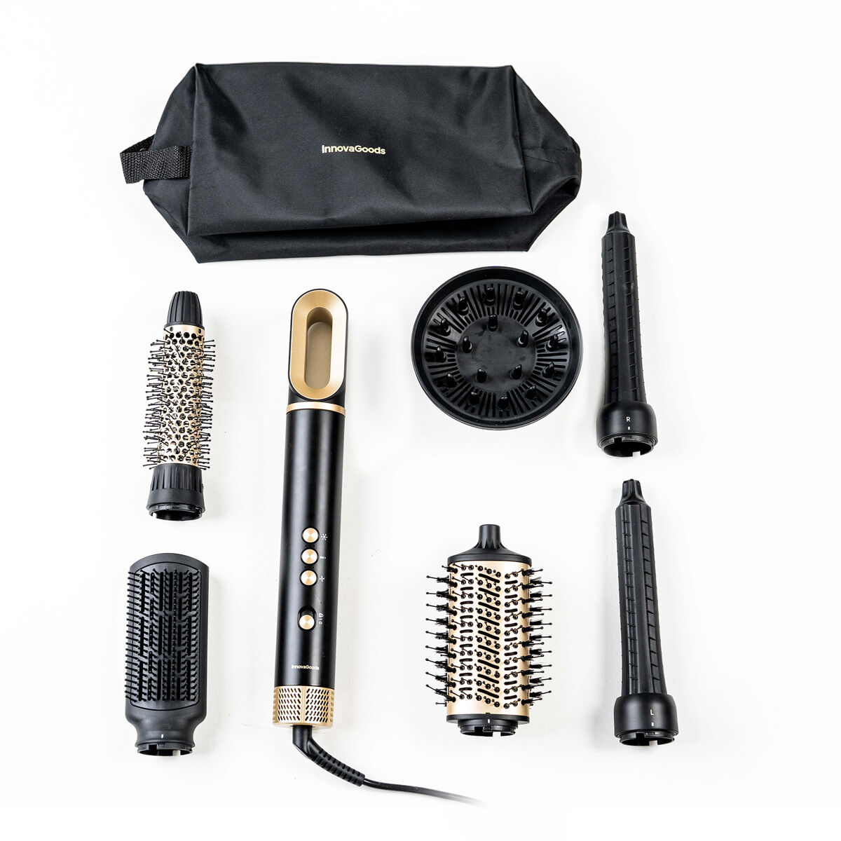 Ein Haarstyling-Set ist auf einer weißen Oberfläche angeordnet. Es umfasst eine schwarze Tasche, einen Haartrocknergriff und verschiedene Aufsätze.